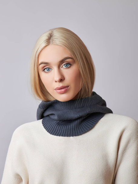 European Muslim woman with a blonde hair in a bonnet hood dressed on her head. Beautiful girl in sweater with soft skin, natural cosmetics - Zdjęcie, obraz