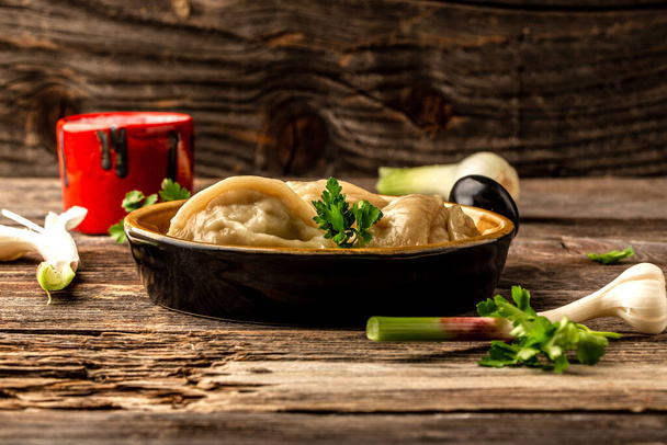 O uzbeque preparou bolinhos Manti ou manty cozidos em uma tigela tradicional na mesa de madeira. lugar de receita de menu de banner para texto
. - Foto, Imagem