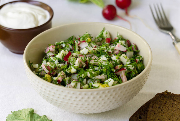 Salad with radish, eggs and dill on a white fabric background - Photo, Image