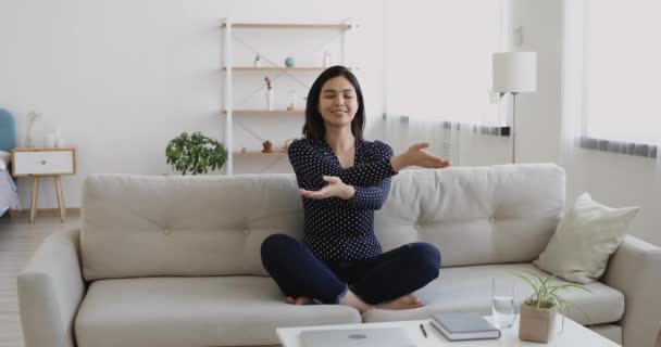 Vietnamese woman closed eyes seated cross-legged breathing do exercise - Filmati, video