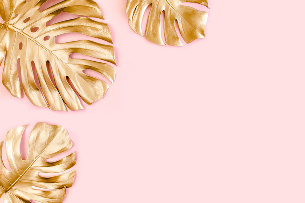 Gold tropical palm leaves Monstera on pink background. Flat lay, top view minimal concept. - Fotoğraf, Görsel