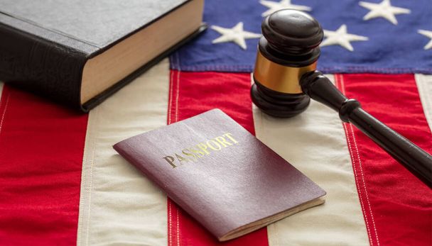 Паспорт и молоток судьи на фоне флага США, вид крупным планом. Иммиграция, концепция визы Соединенных Штатов Америки
 - Фото, изображение