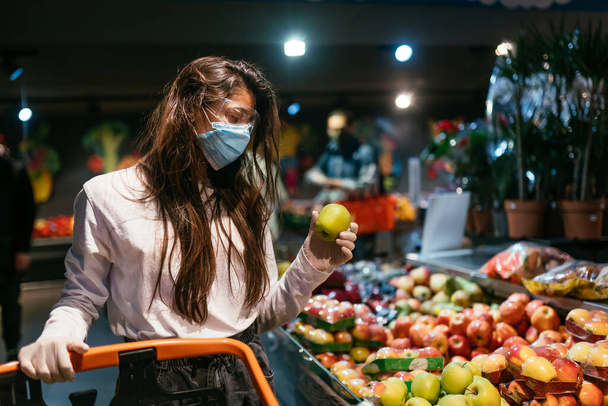 The girl with surgical mask is going to buy apples. - Photo, Image
