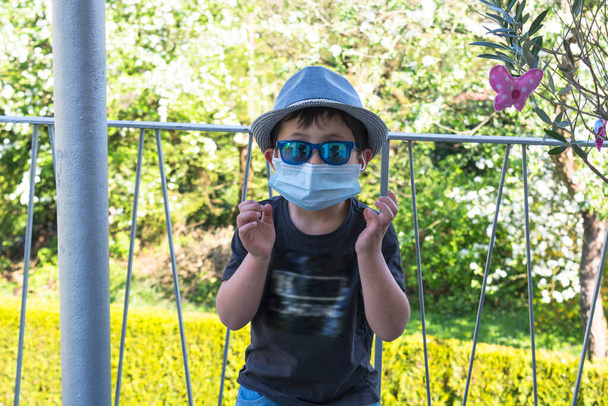 Preteen αγόρι με μια ιατρική μάσκα δείχνει χειρονομία - Φωτογραφία, εικόνα