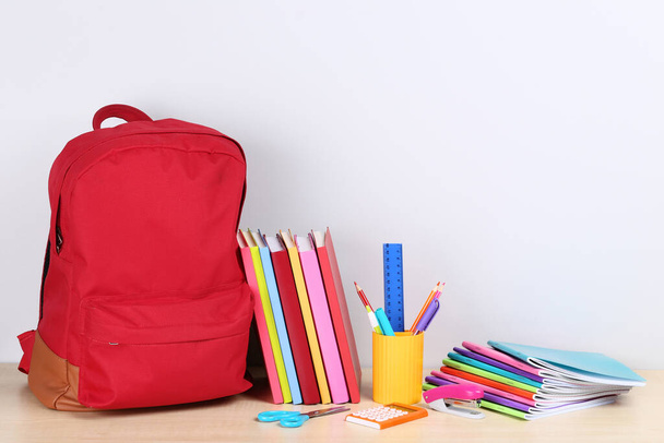 Backpack with school supplies on grey background - Photo, image