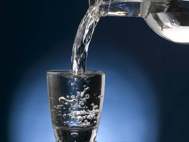 Een glas water, overvol. Close-up - Foto, afbeelding