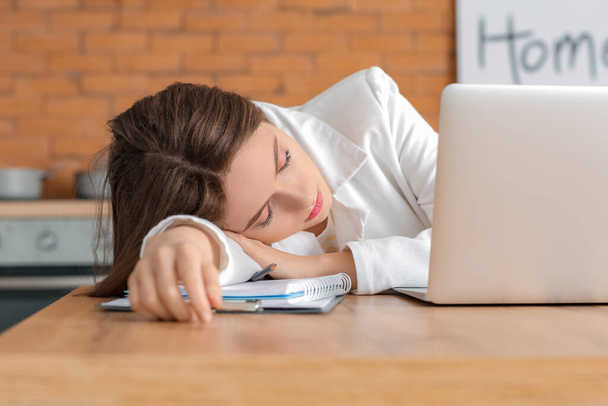 Νεαρή γυναίκα κοιμάται κατά τη διάρκεια της εργασίας στο σπίτι. Έννοια της στέρησης ύπνου - Φωτογραφία, εικόνα