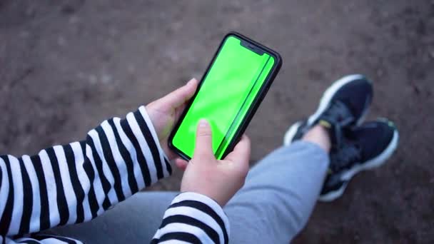 Womans χέρι κρατώντας σύγχρονο Smartphone, αγγίζοντας την πράσινη οθόνη, κλέβοντας φωτογραφίες - Πλάνα, βίντεο