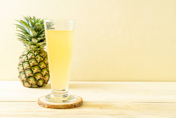 fresh pineapple juice on wood background - Fotó, kép