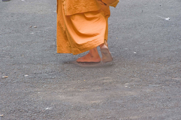 zen monnik in oranje kleding lopen blootsvoets in de straten van Vietnam - Foto, afbeelding