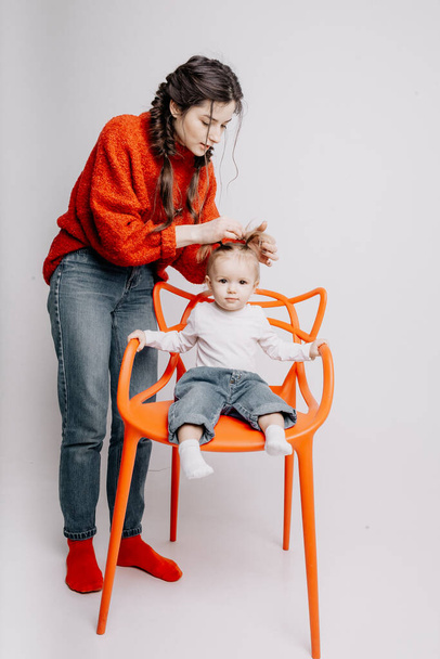mom and daughter in photo studio getting ready to shoot, mom combing her baby's hair - Фото, зображення