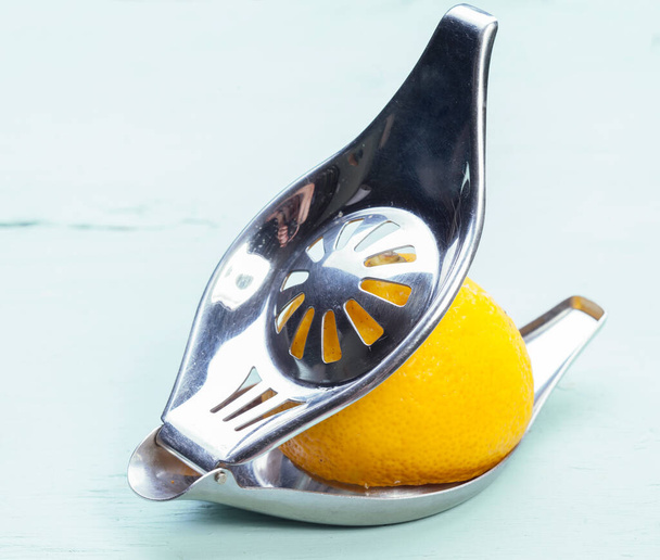柑橘類のジュースや白の背景にレモンスライスのプレスを絞るためのレトロなデバイス - 写真・画像