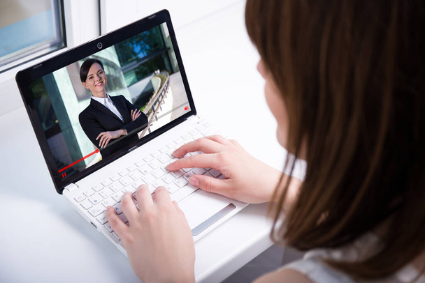 wideo blog koncepcja - młoda kobieta ogląda filmy biznesowe na laptopie w domu - Zdjęcie, obraz