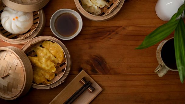 Vista superior de albóndigas al vapor que sirven en la costurera de bambú en la mesa de madera con espacio para copiar en los restaurantes chinos
 - Foto, Imagen