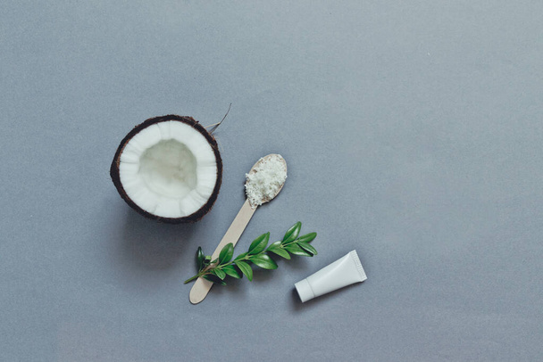 Handmade organic cosmetics with coconut on a grey background from above. - Фото, изображение