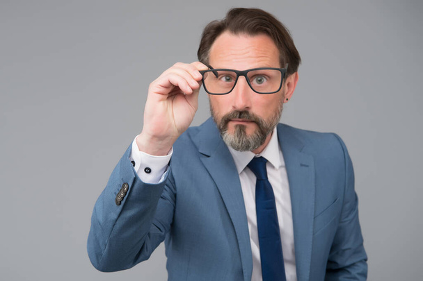 Serious businessman. Education for adults. Self education. Teacher lecturer speaker. Intelligent concept. Hard to answer. Difficult question. Perplexedly removes glasses. Business education - 写真・画像