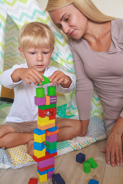 Mom and son build a tower together from the constructor - Photo, image
