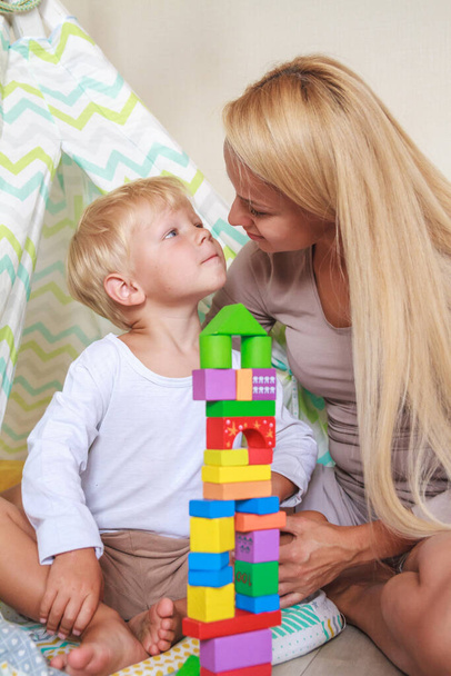 Mom and son build a tower together from the constructor - Foto, Bild
