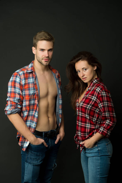 Family look. Fashion trend. Fashionable outfit. Woman and man wear checkered shirt. Sexy stylish couple black background. Young family couple. Summer fashion collection. Beautiful people concept - Fotó, kép