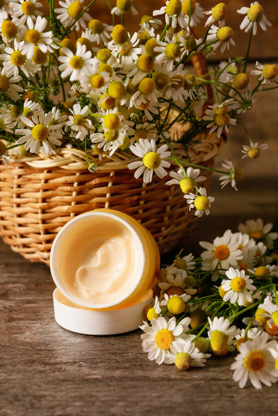 Crema cosmetica fiori di camomilla su sfondo di legno - Foto, immagini
