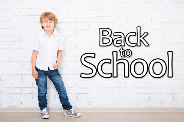 back to school - portrait of little school boy in glasses over white brick wall - Foto, Imagen