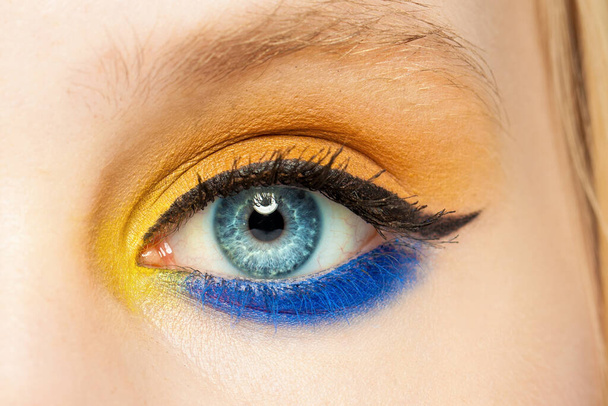 Eye closeup. Female eye with eyeshadow and black eyeliner arrow makeup close up - Valokuva, kuva