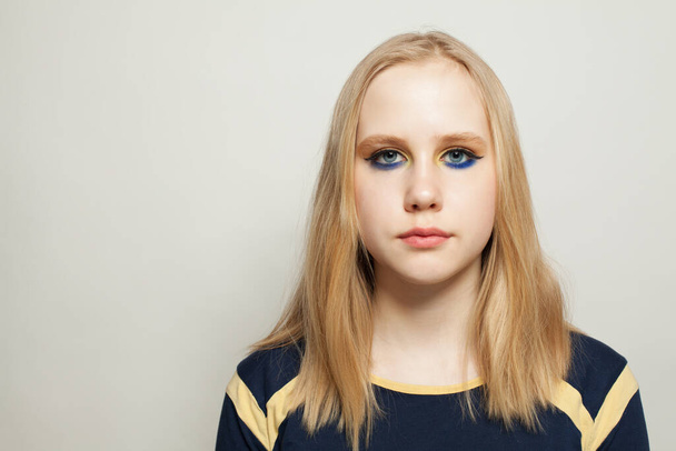 Stylish girl with blue eye shadow makeup on white background - Фото, зображення