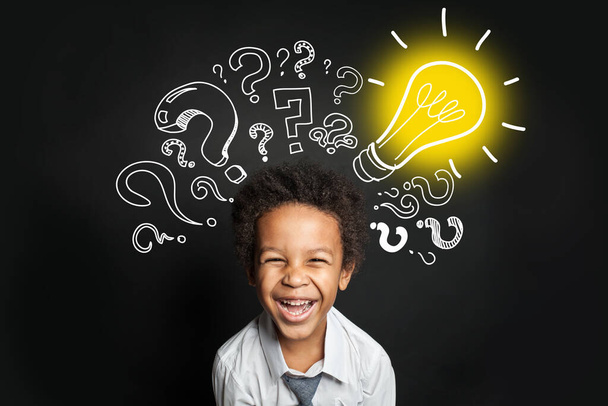 Lightbulb, question marks and smart laughing child. Brainstorming and idea concept - Zdjęcie, obraz
