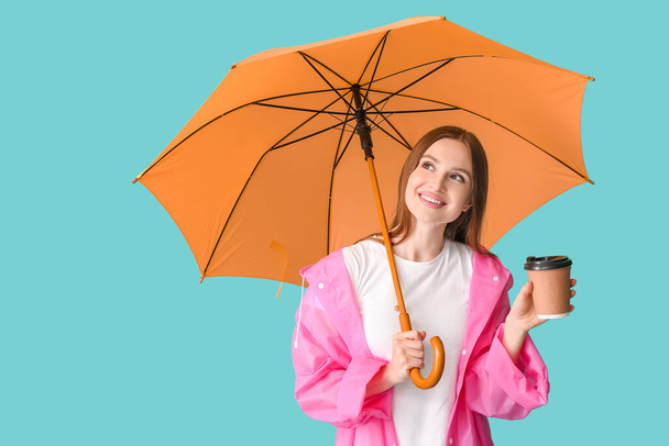 Beautiful woman with umbrella and cup of coffee on color background - Foto, imagen