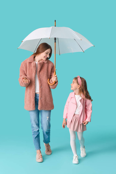 Mother and little daughter with umbrella on color background - Zdjęcie, obraz