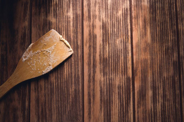 A closeup shot of a wooden spatula on a wooden table - Фото, зображення