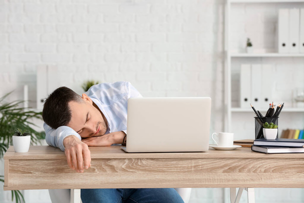 Genç adam ofiste çalışırken uyuyakalıyor. Uykusuzluk kavramı - Fotoğraf, Görsel