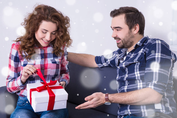 valentine's day or christmas concept - young woman opening gift from her boyfriend - Fotó, kép