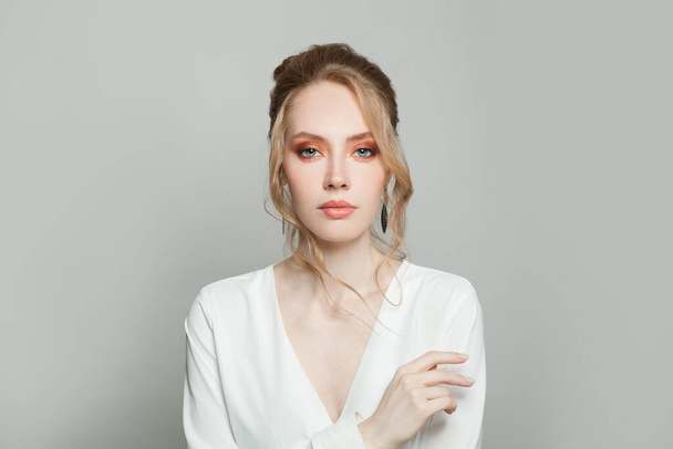 Jovem mulher perfeita com penteado elegante em blusa branca
 - Foto, Imagem