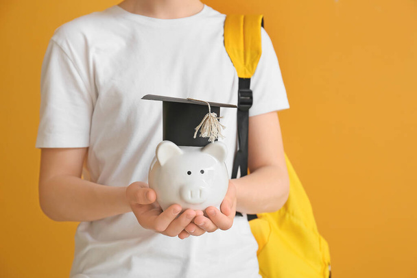 Adolescente con ahorros para la educación en el fondo de color
 - Foto, Imagen