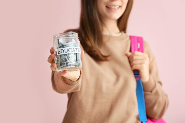 Teenage girl with savings for education on color background, closeup - Foto, immagini