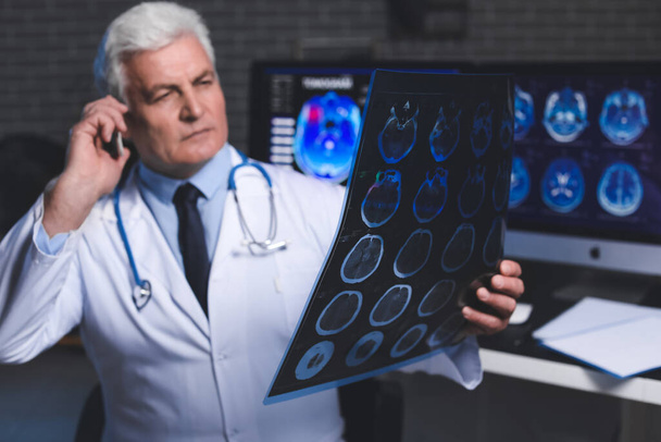 neurologue principal avec IRM scanner de la tête humaine parler par téléphone portable à la clinique - Photo, image