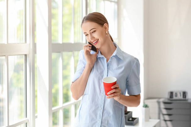 Beautiful businesswoman talking by phone in office - Foto, Imagen