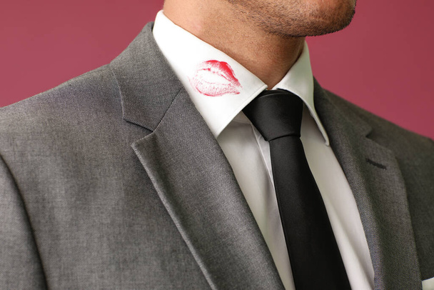 Fiatal üzletember ajkakkal nyomtat ing gallér ellen színes háttér, közelkép - Fotó, kép