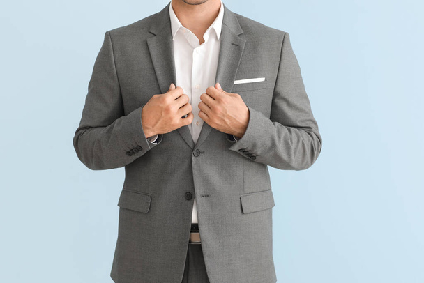 Jeune homme d'affaires en costume élégant sur fond de couleur - Photo, image