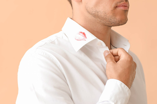 Young businessman with lips print on shirt collar against color background, closeup - Photo, Image