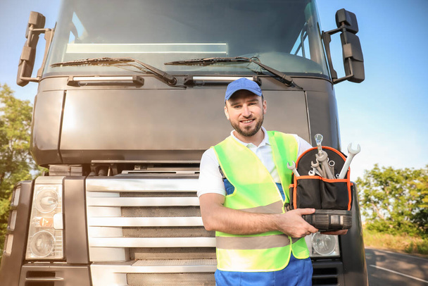 Chauffeur masculin avec des outils près de gros camion à l'extérieur - Photo, image