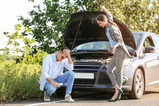 Young couple quarreling near broken car on road - Photo, Image