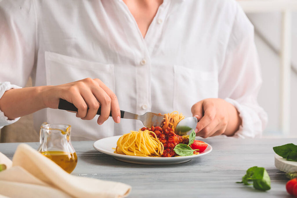 Woman eating tasty pasta bolognese at table, closeup - Photo, Image
