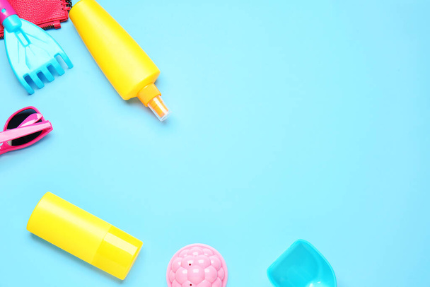 Крем для загара с пляжными песчаными игрушками на цветном фоне
 - Фото, изображение