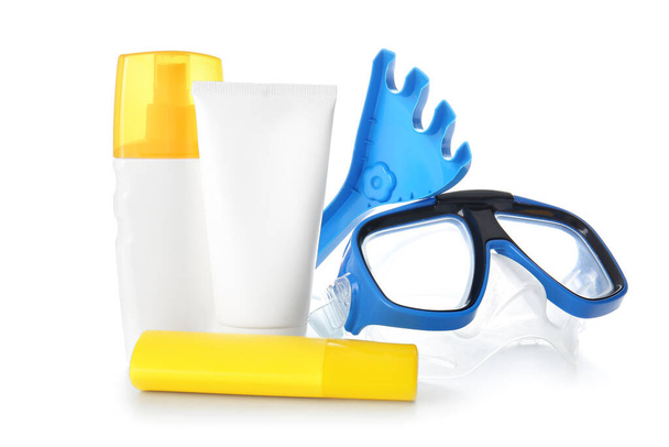 Crema protector solar con juguetes de arena de playa y máscara de snorkel sobre fondo blanco
 - Foto, imagen