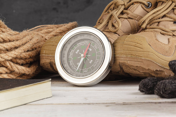 Compass surrounded by mountain gear tools on wooden background - Foto, immagini