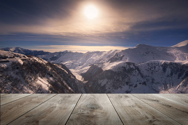 красивий зимовий захід сонця над горами і порожній дерев'яний стіл у природі на відкритому повітрі. Ландшафт натуральних шаблонів
 - Фото, зображення