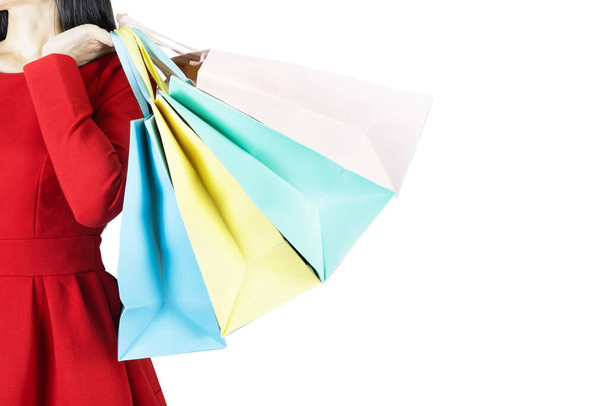 jovem mulher bonita em vestido vermelho carregando cor saco de compras pastel isolado banner fundo branco com espaço de cópia
 - Foto, Imagem