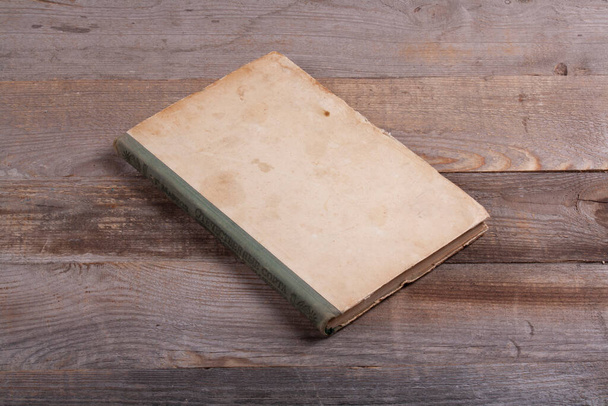 Very old vintage book on a dark wooden background. - Foto, afbeelding